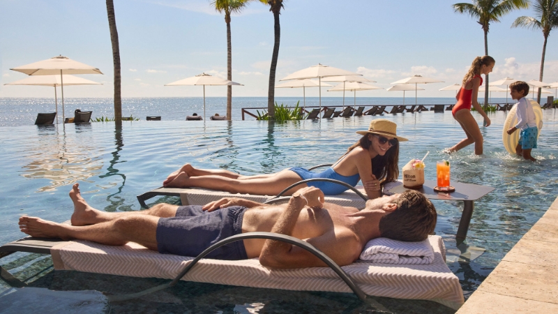 Family at the pool at Hilton Cancun All Inclusive Resort
